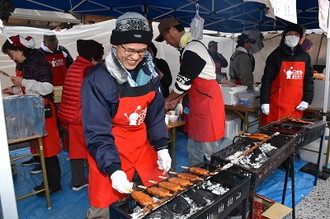 写真：笑顔で五平餅を焼く男性