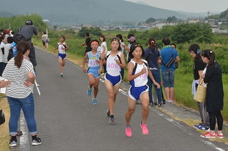 写真：土岐川堤防を走るランナーたちと、堤防の際に並んで応援する市民