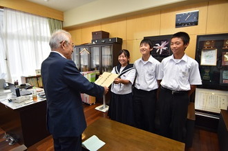 写真：岐阜県共同募金会の日比野昭会長に生徒会の3人が義援金を手渡しする様子