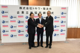 写真：トキワ企業立地協定で三人の男性が握手をしている様子