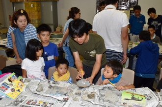 写真：化石のクリーニングを教わっている子どもたちの様子