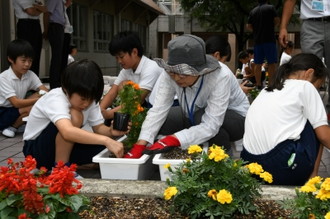 写真：プランターに花を植える人権擁護委員と子どもたち