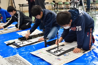 写真：普通サイズの紙に書き初めする様子