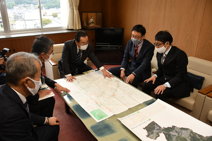 国土地理院と市長が地図を見ている写真
