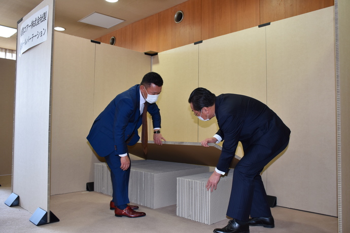 東濃コアー株式会社代表取締役と市長が段ボールベッドを見ている写真
