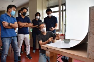 写真：講師がスマホで湯呑を撮影する様子