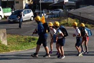写真：警察官扮する不審者から逃げる児童たちの様子