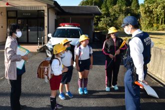 写真：交番前で警察官の話を聞く児童の様子