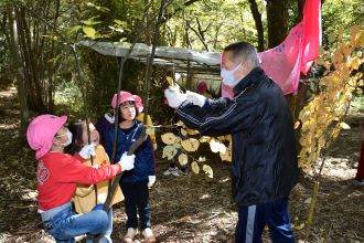 写真：自然ふれあい館職員が園児に木の葉の説明をしている様子