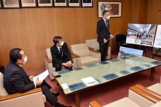 写真：市長が田中さんの説明を聞いている様子