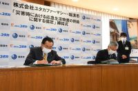 写真：市長と浅井社長が協定書に署名する様子