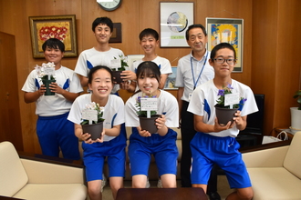 写真：瑞浪北中学校お生徒と教育長が花を持っている様子